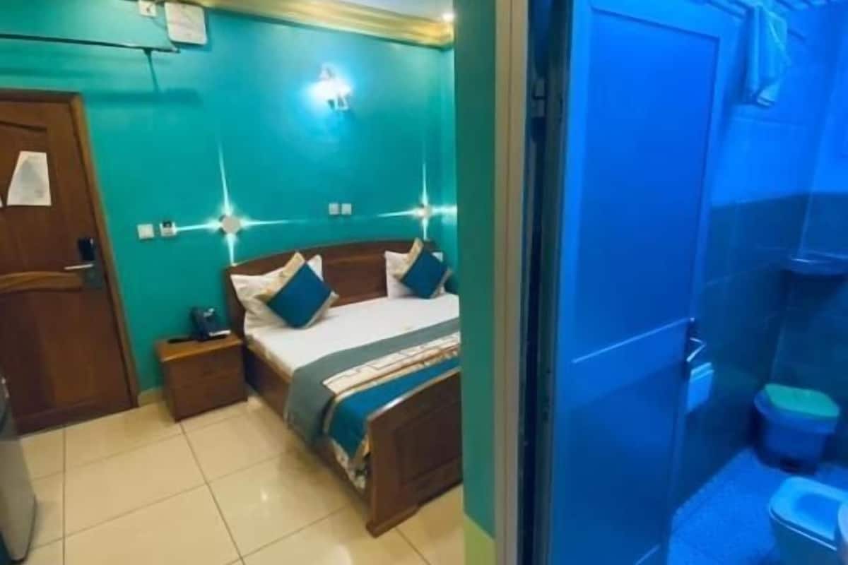 Une chambre à coucher avec un lit, des tables de chevet et une armoire.