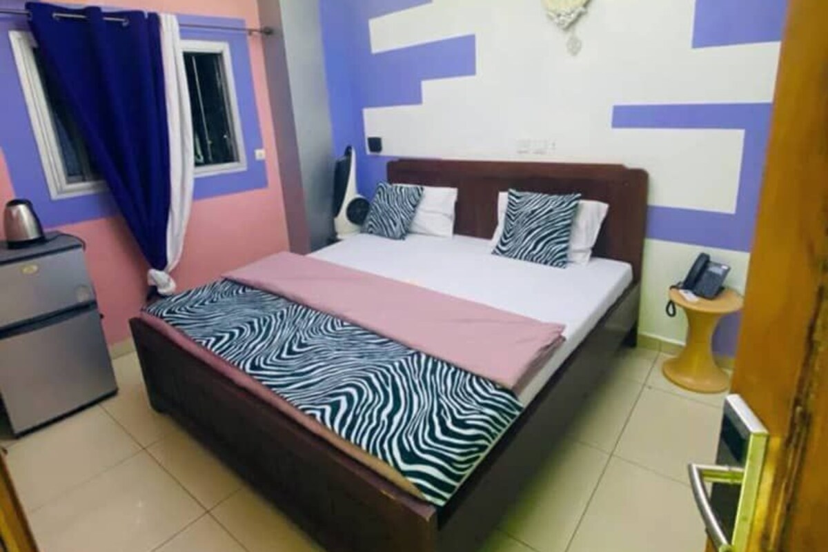 A bedroom with a bed, a desk, and a chair.