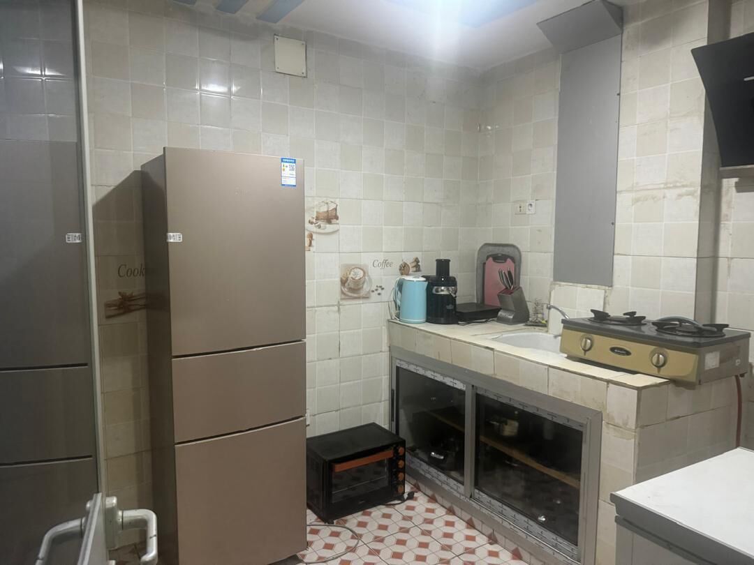 A compact kitchen with a refrigerator, a coffee maker, a toaster, and a microwave.