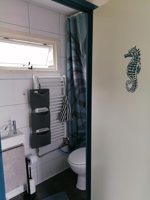 Een douche, een haardroger, handdoeken, toiletpapier