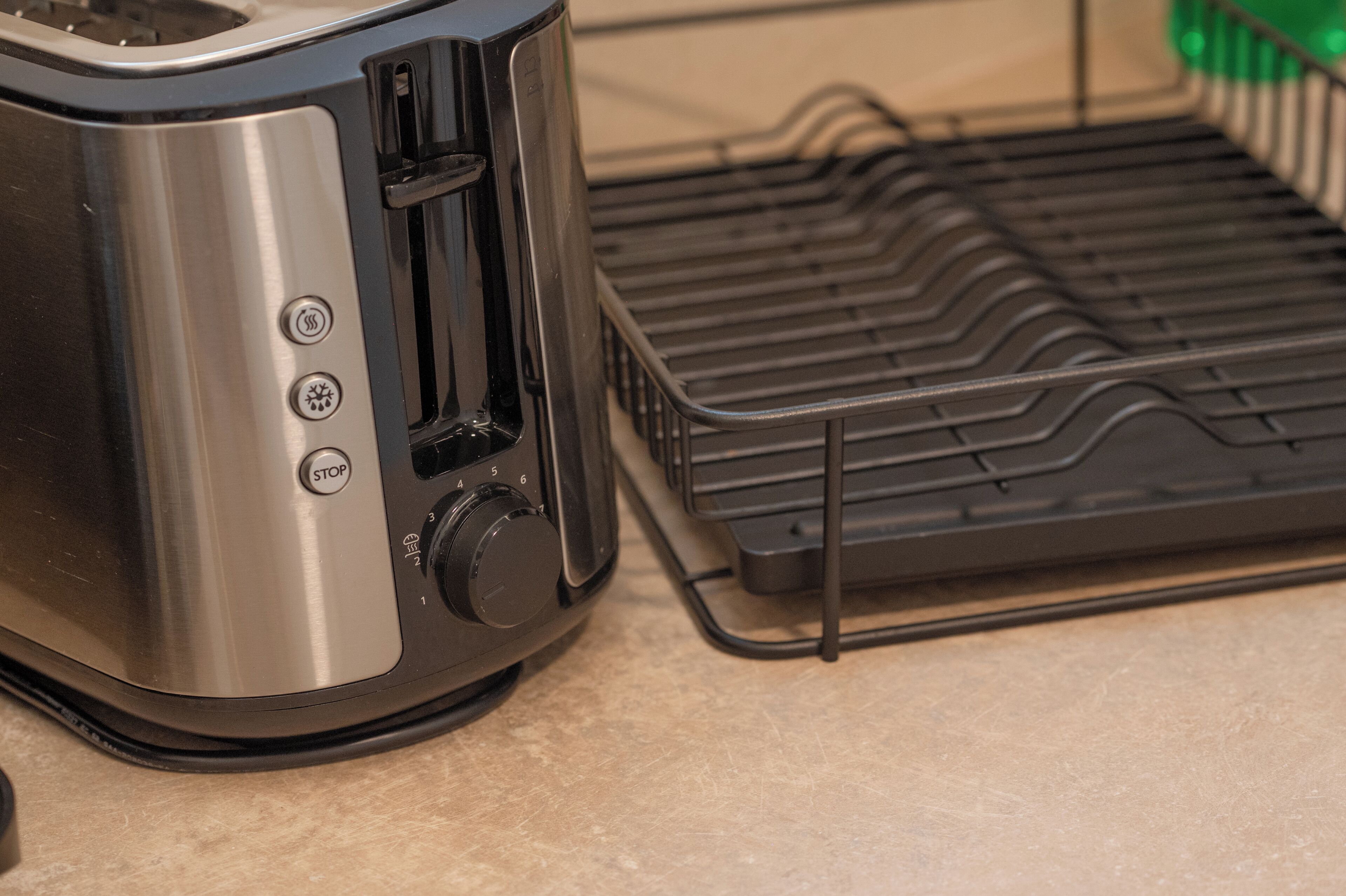 A toaster with a black tray and a stainless steel body.