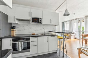 Enjoy meals in this well-equipped kitchen with a microwave, sink, and window overlooking the dining area.