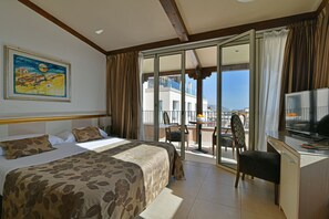 A hotel room with a bed, a desk, a chair, and a balcony with a view. - Hotel Le Chevalier (Taormina)