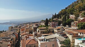 Un pueblo costero con edificios de techos de teja rojiza, una iglesia destacada y vistas al mar.