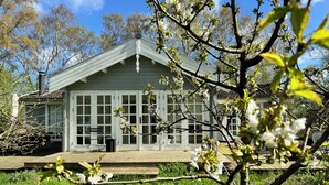 Une maison avec un porche, de grandes fenêtres et une pelouse.