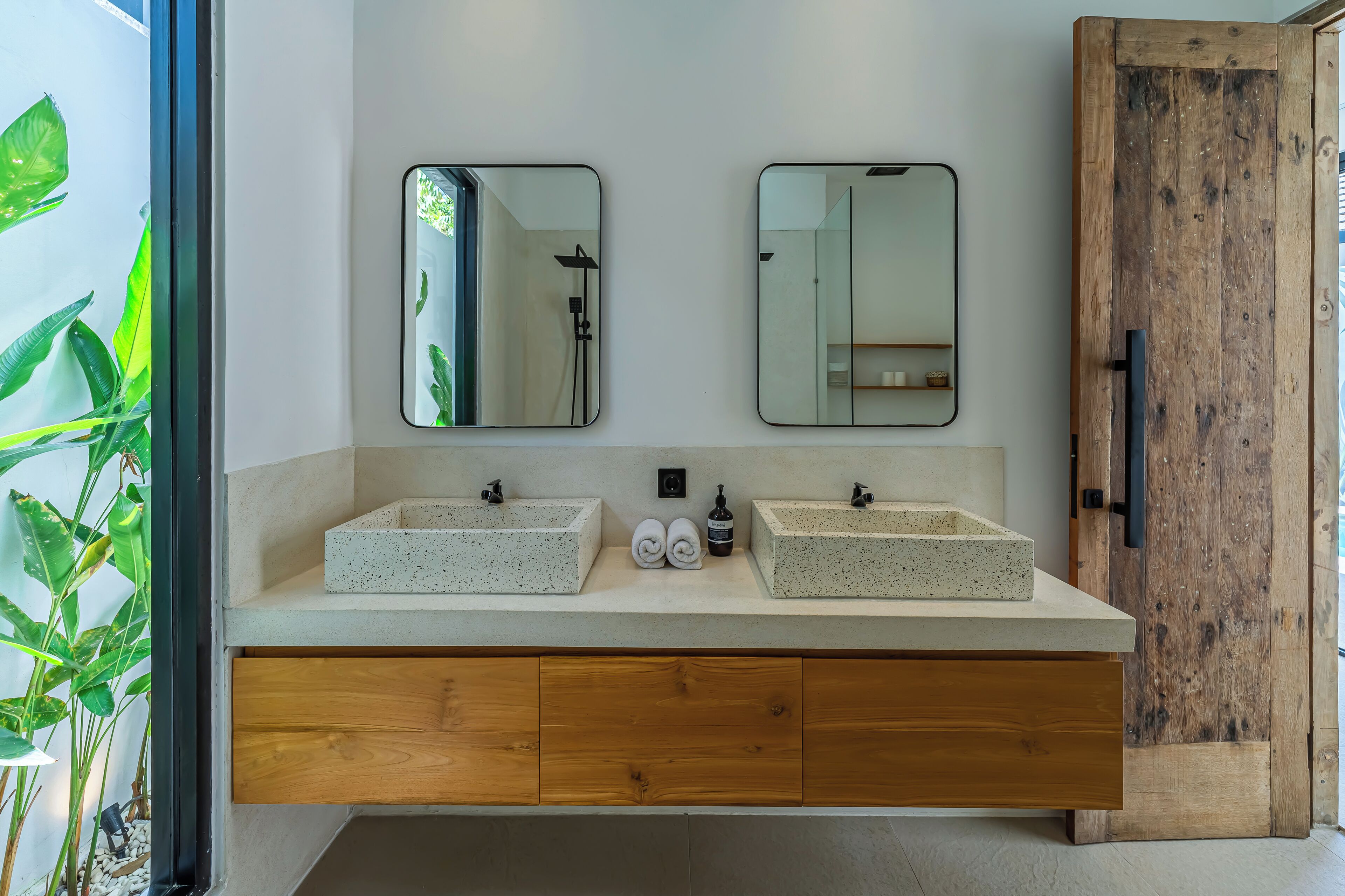 A bathroom with two freestanding sinks, wooden cabinets below, and a large mirror above.