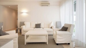 Een moderne woonkamer met een witte bank, een bijzettafeltje en een salontafel.