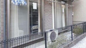 A residential building with large windows, a metal fence, and a clothesline with laundry. - 201_Shinjuku Gourmet&Shopping Recently (新宿区)