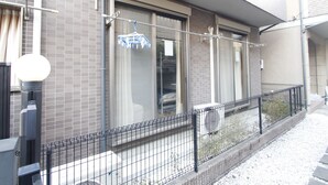 A residential building with a balcony, a black metal fence, and a window with a curtain. - 201_Shinjuku Gourmet&Shopping Recently (新宿区)