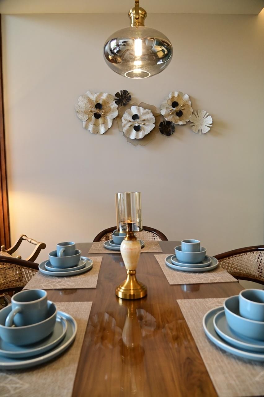 A dining table set with blue dishes and a brass candle holder.