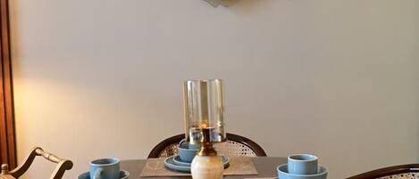A dining table set with blue dishes and a brass candle holder.
