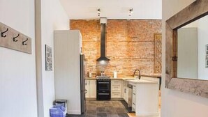 Eine moderne Küche mit Backsteinwand, Herd und Spüle.