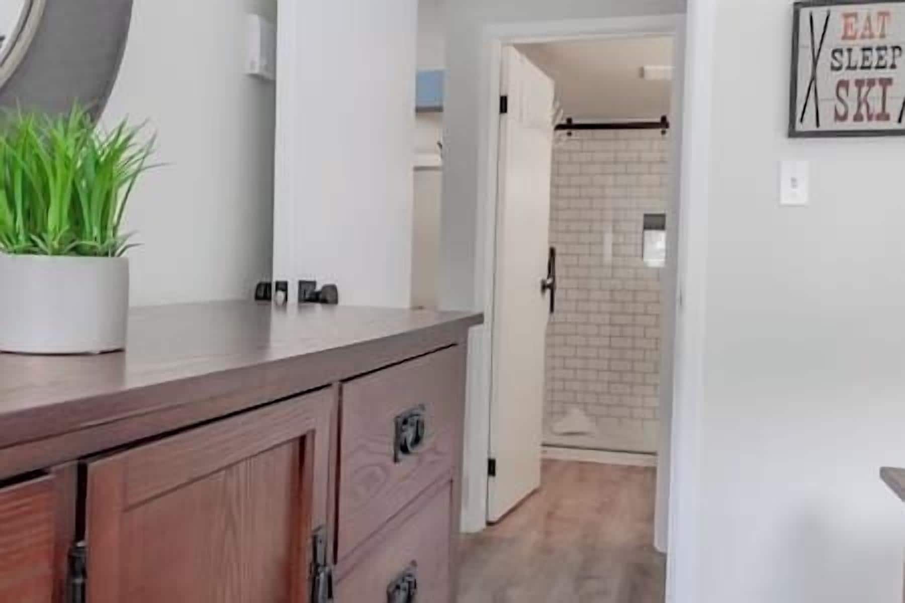 Een moderne keuken met een houten aanrecht, een potplant en een bord aan de muur.