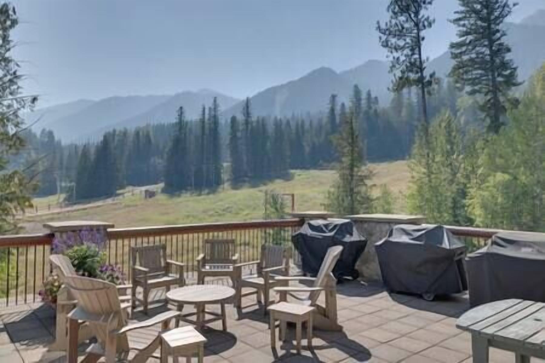 A patio with outdoor furniture and a view of a mountainous landscape.