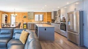 A modern kitchen with stainless steel appliances, a central island, and wooden cabinetry.