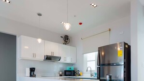 A modern kitchen with white cabinets, a black refrigerator, and a checkered floor pattern. - w* | Perfect 2BR in Casco Antiguo w/ Balcony (Panamá)