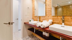 A bathroom with two sinks, a wooden wall, a large mirror, and a towel rack. - w* | Vivid 1BR w/ Magical lighting in Panama (Panamá)