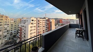 A balcony with a view of surrounding buildings and a clear sky. - 2 Bedroom Apartment Tirana/ Family friendly (Tirana)