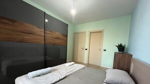 A modern bedroom with a bed, a wardrobe, and a potted plant. - 2 Bedroom Apartment Tirana/ Family friendly (Tirana)
