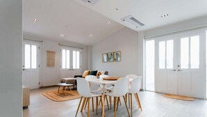 A spacious room with a round dining table, white chairs, and a light-colored floor. - w* | Welcoming 2BR w/ Terrace in Panama (Panamá)