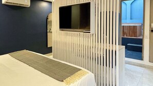 A modern hotel room with a bed, a mounted TV, and a sliding door leading to a balcony. - w*| Awesome 2BR w/ 2 Jacuzzis  in El Poblado (Medellín)