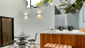A modern kitchen with a wooden bench, a round dining table with wire chairs, and a built-in sink. - w*| Awesome 2BR w/ 2 Jacuzzis  in El Poblado (Medellín)