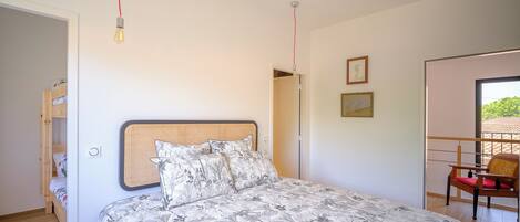 Ein Schlafzimmer mit Bett, Stuhl, Tür und Fenster.