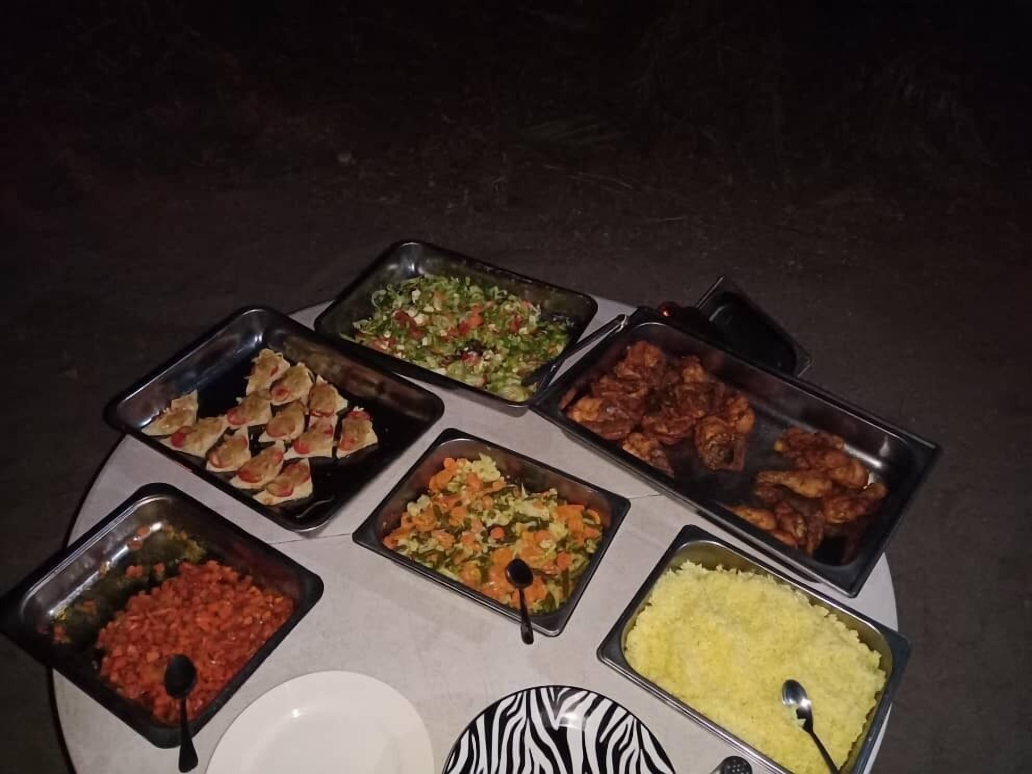 Een buffettafel met diverse gerechten, zoals rijst, groenten en vlees.