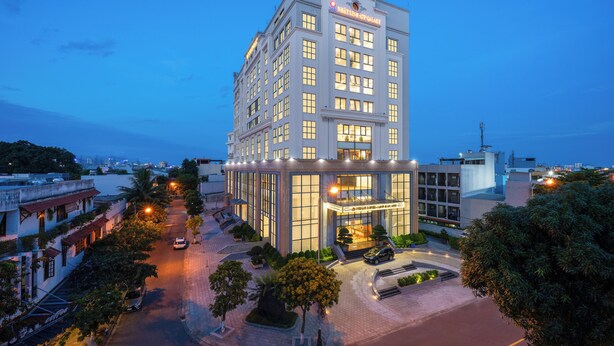 A modern hotel with a prominent entrance, multiple floors, and a well-lit facade. - ATP Galaxy Hotel & Apartment Danang (Da Nang)