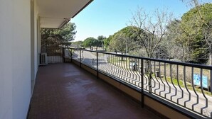 A balcony with a metal railing, a clear view of the street, and trees in the background. - Linda 19 - Lido di Jesolo, Italy. Entire Housing (Lido di Jesolo)