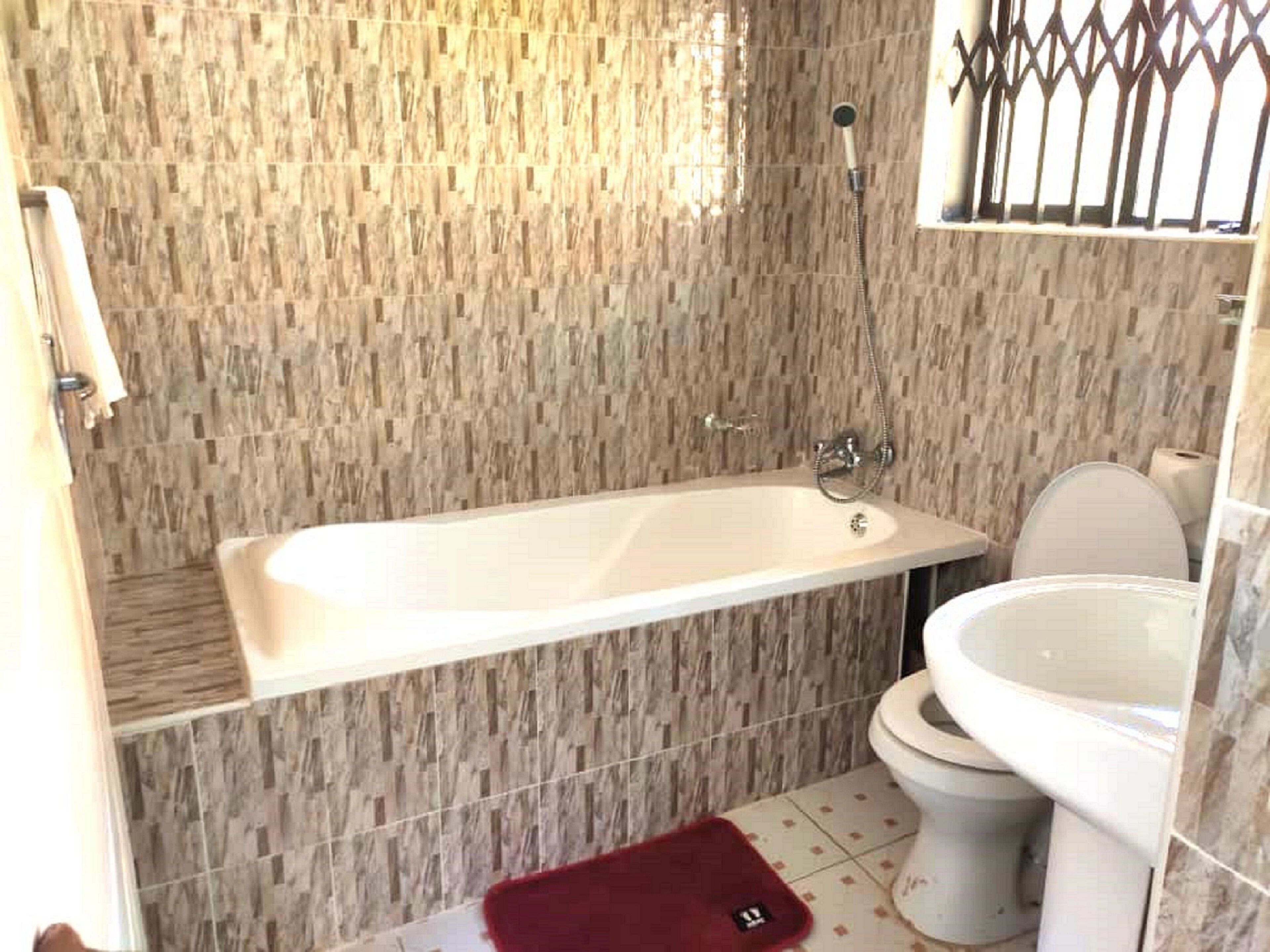 A bathroom with a freestanding bathtub, a toilet, and a sink.