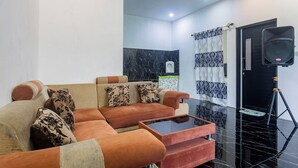 Un salon moderne avec un ensemble de canapés, une table basse et un mur d’accent en marbre noir.
