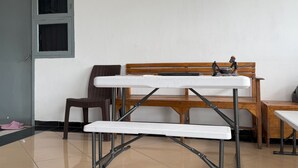 A room with a wooden bench, a white table, and a chair. - Hotel O Kost Stan (Negeri Lama)