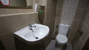 Un baño con lavamanos blanco, inodoro y cortina de ducha.
