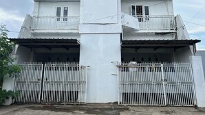 Un edificio blanco con un letrero que dice "IPSUM DIGITAL X" y una entrada con portón.