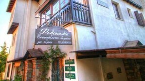 Un edificio a due piani con un cartello che riporta la scritta 'Pensione Doria'.