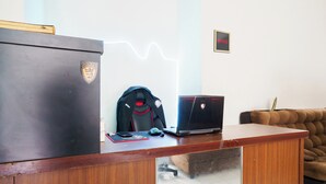 Een houten bureau met een laptop, een muis en een rugzak.