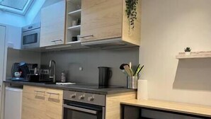 Une cuisine moderne avec des meubles en bois, un four encastré et une machine à café.