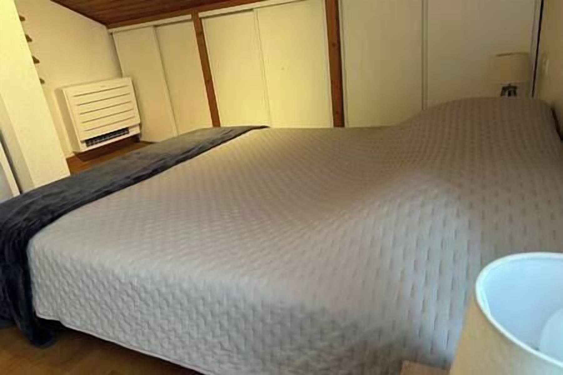Une chambre à coucher avec un lit, un radiateur et une fenêtre.