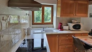 A kitchen with wooden cabinets, a window, a sink, and a microwave. - Ispahan - Grand Duplex Avec 2 Chambres Indépendantes (Saint-Martin-d'Uriage)