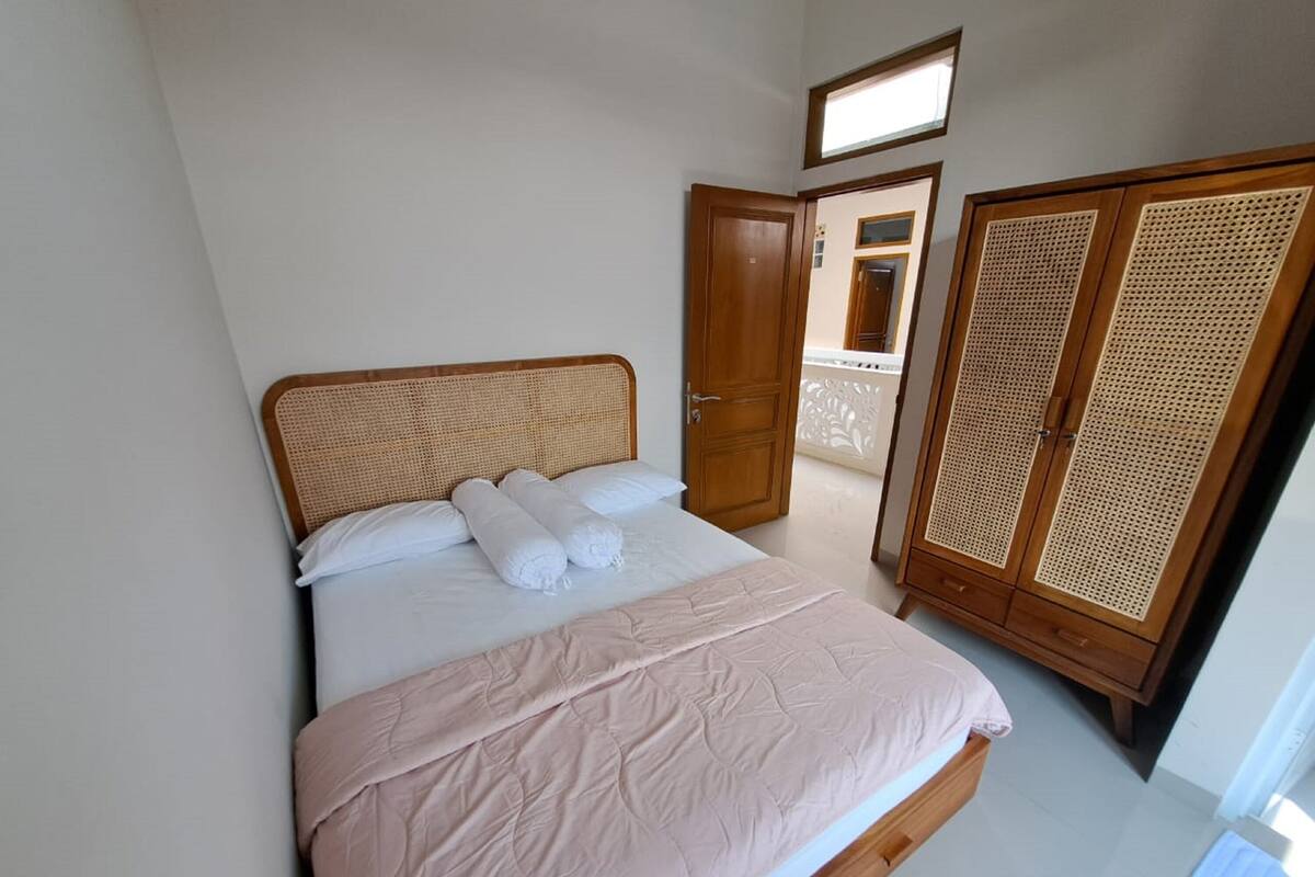 Un dormitorio con cama, armario y balcón.