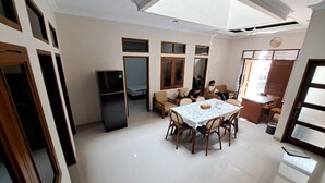 Un grand espace de vie comprenant une table à manger, des canapés et un coin cuisine.