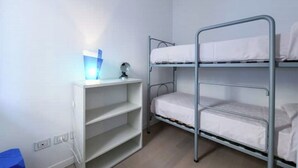 Una camera con un letto a castello, una scrivania e una lampada.