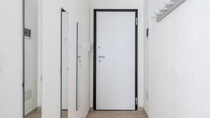 A narrow hallway with a wooden floor, white walls, and a door at the end. - A pochi passi dal Mercato delle Erbe by Wonderful Italy (Bologna)