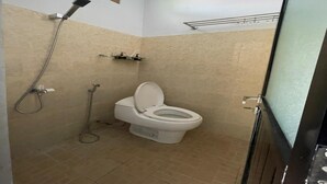 Un bagno piccolo con un water, una doccia e un lavandino.
