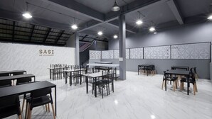 Un interior de restaurante moderno con suelo de mármol, mesas y sillas de madera y color negro.