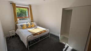 A bedroom with a bed, bedside table, and a wardrobe. - Greenhithe Flat-kent- 20 Mins to London-petsok (Greenhithe)