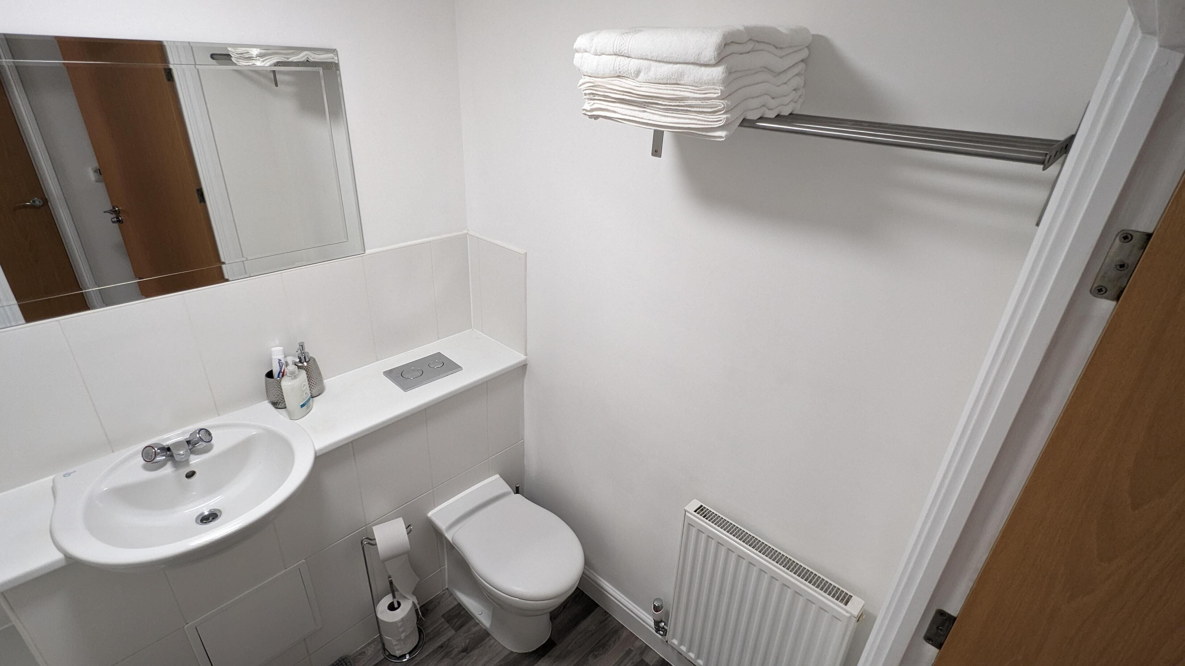 Ein modernes Badezimmer mit Waschbecken, Toilette und Handtuchhalter.