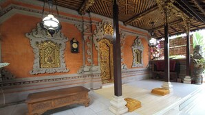 An ornate interior with a wooden bench, a clock, and a decorative ceiling. - Capital O 94011 Binhari Guest House (Ubud)