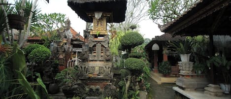 A traditional Balinese temple with intricate carvings, a central shrine, and lush tropical vegetation.